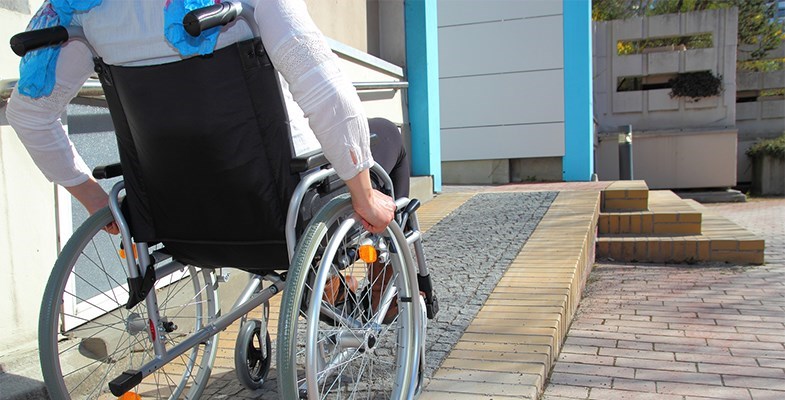 person in wheelchair going up a ramp